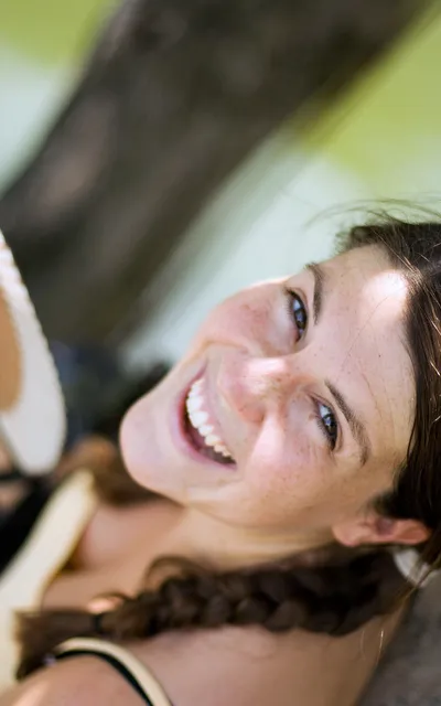 Mulher sorrindo, ao ar livre.