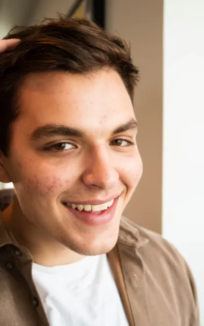 Homem sorrindo, ao ar livre.
